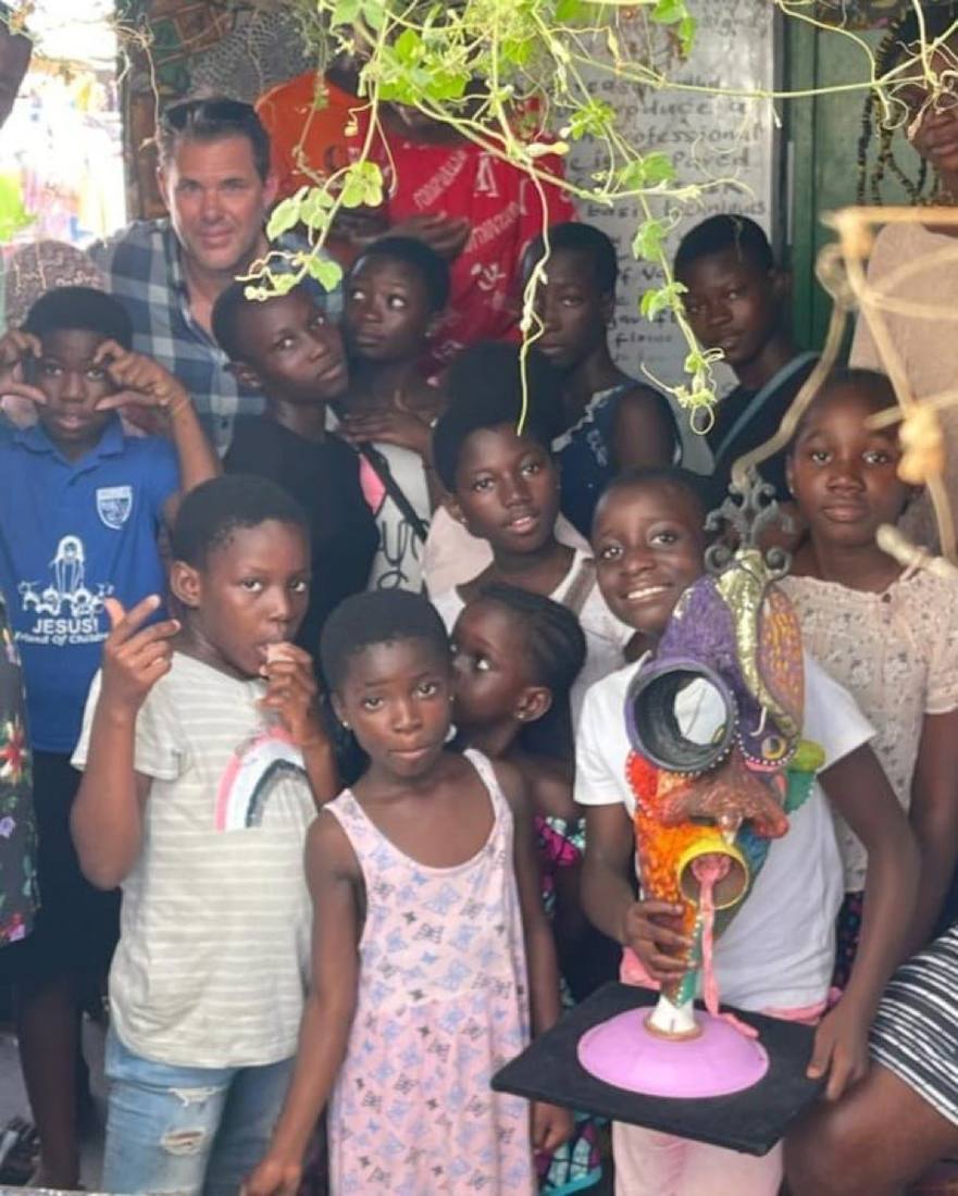 Community engagement with local youth in Ghana, featuring upcycled art from reclaimed materials